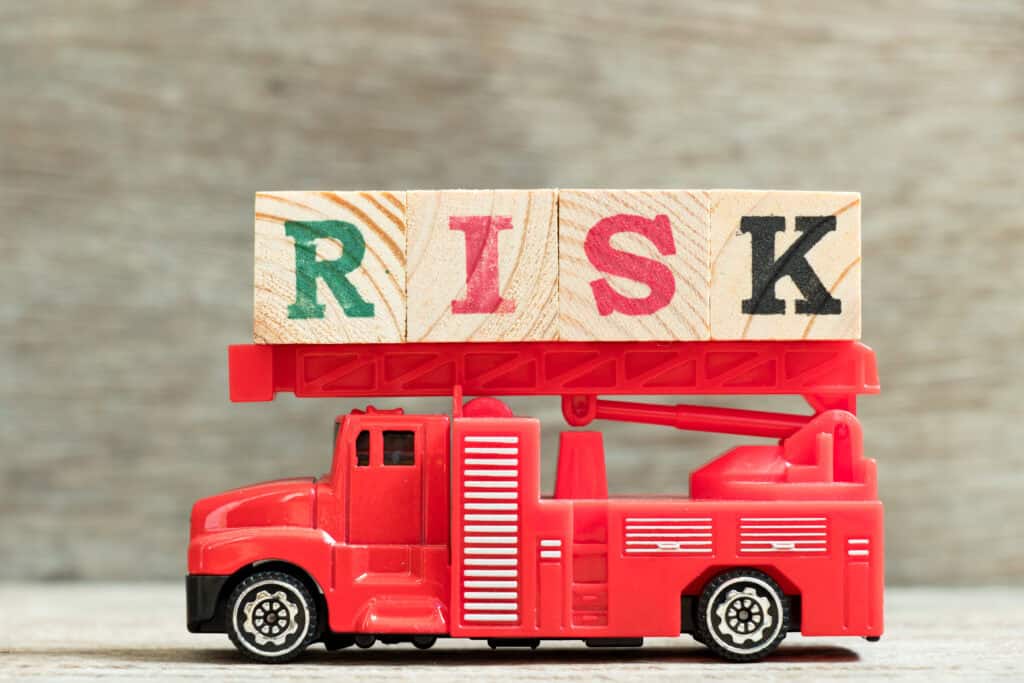 Fire risk assessment illustrated by a toy fire engine with wooden blocks spelling out risk